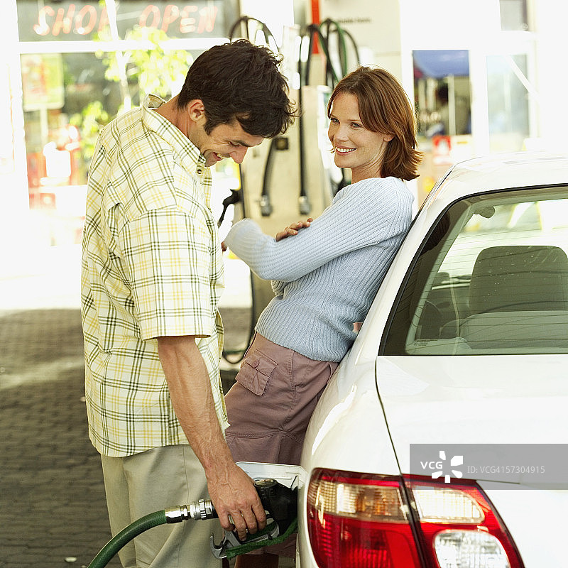 年轻女子向汽车油箱中加油图片素材