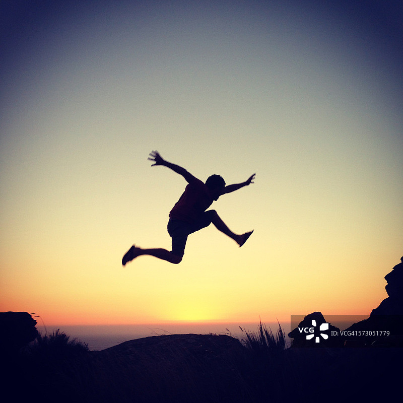 夕阳下跳跃的男人轮廓图片素材