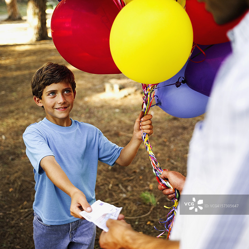 男孩向气球摊贩买气球图片素材