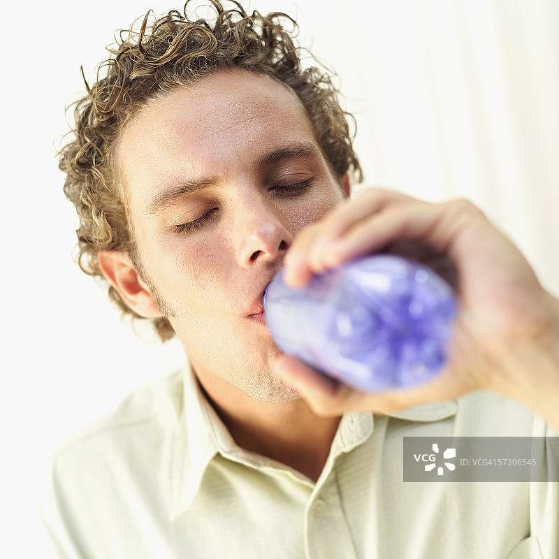 男人近距离饮用瓶装水图片素材