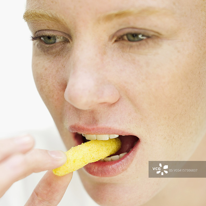 年轻女人吃薯片特写图片素材