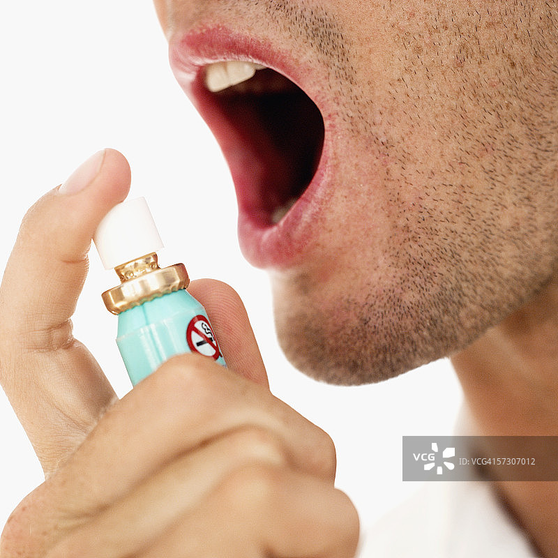 男人往嘴里喷清新剂特写图片素材