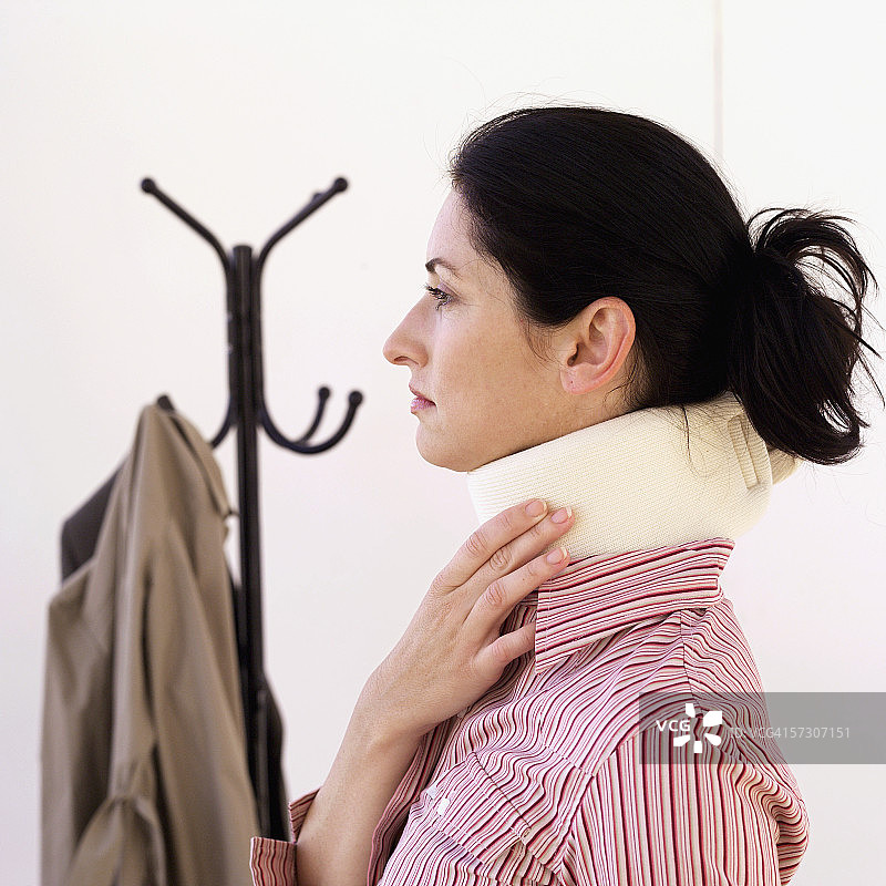 年轻女子侧身佩戴颈托图片素材