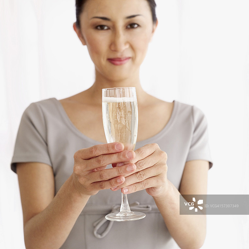 手持一杯香槟的年轻女子肖像图片素材