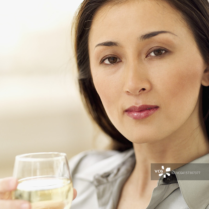 年轻女性手持白葡萄酒杯特写图片素材