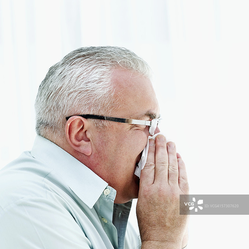 老年男人擤鼻涕侧面照图片素材