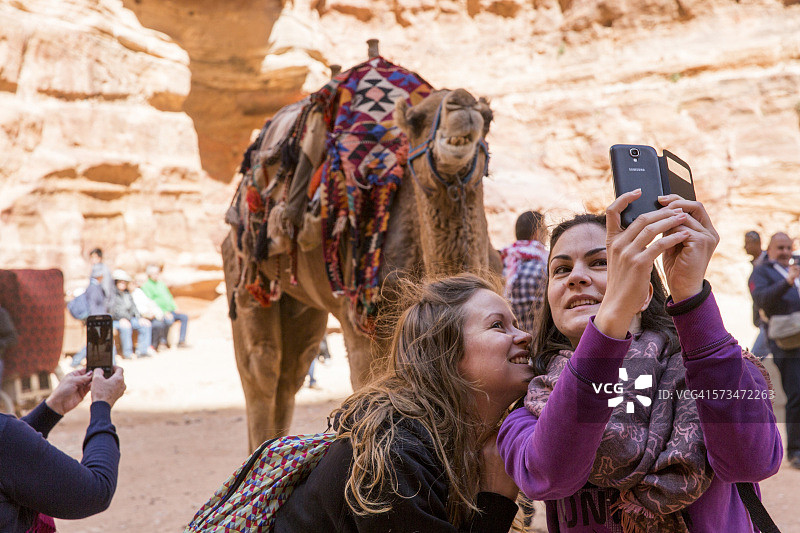 约旦佩特拉遗址的游客与骆驼图片素材