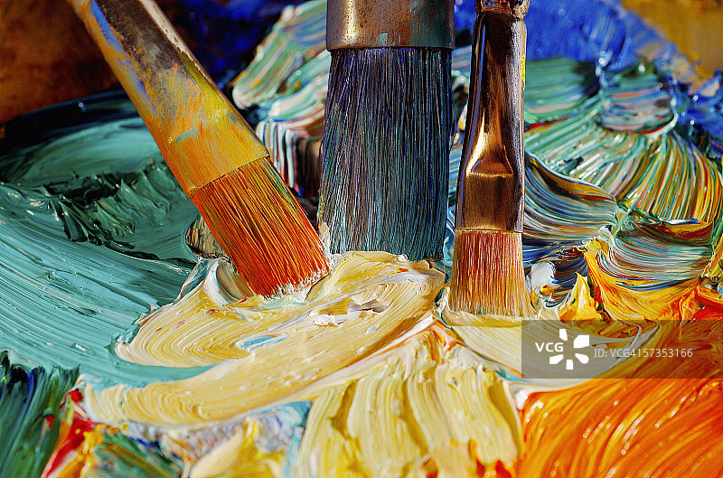 俯视角度拍摄的调色板上混合颜料的画笔图片素材