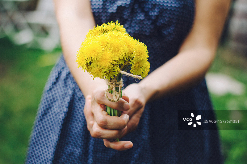 手持黄色蒲公英花束的女孩图片素材