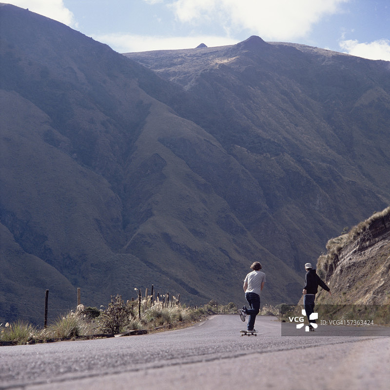 两个年轻男人在陡峭的道路上玩滑板图片素材