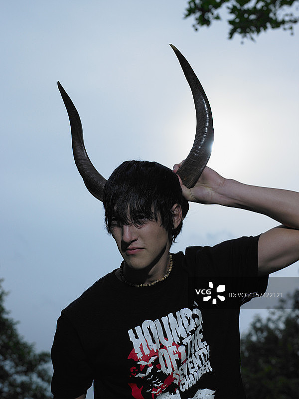 少年拿着动物的角图片素材