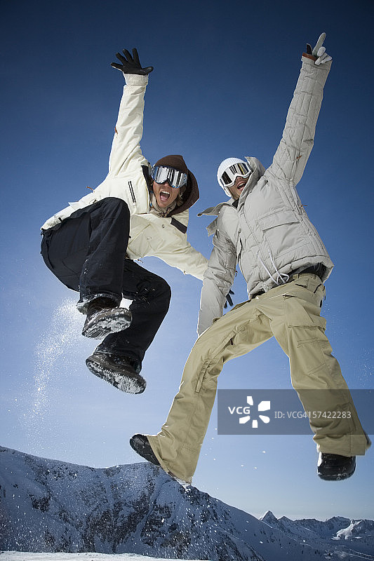 两个年轻男人跳跃的低角度视图图片素材