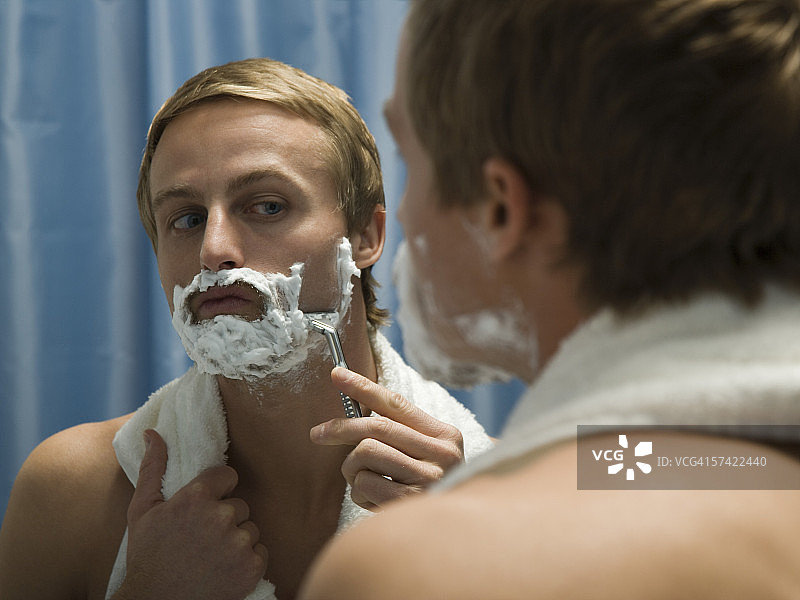 年轻男人刮胡子的特写镜头图片素材