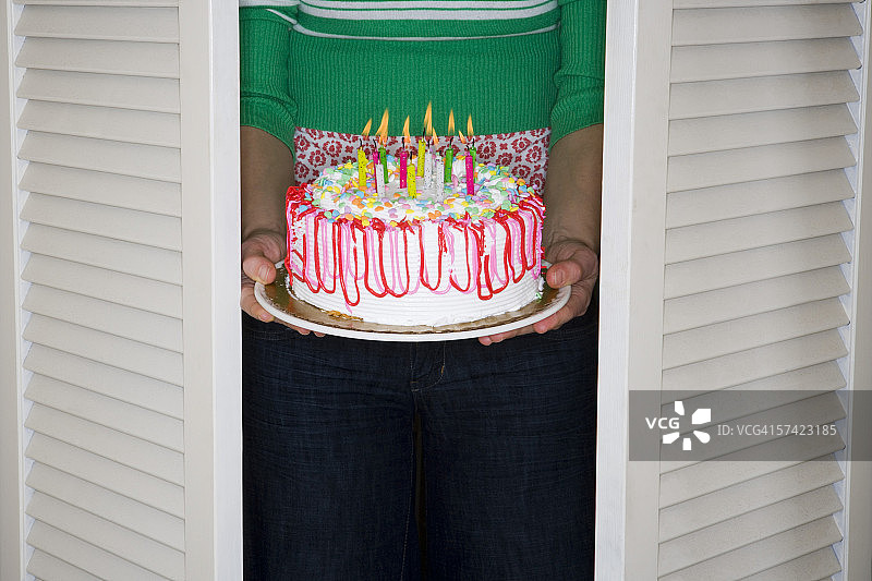 拿着生日蛋糕的女人的腰部视图图片素材