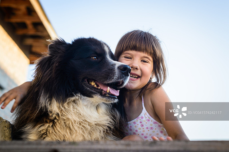 快乐的年轻女孩拥抱雅库茨克莱卡犬图片素材