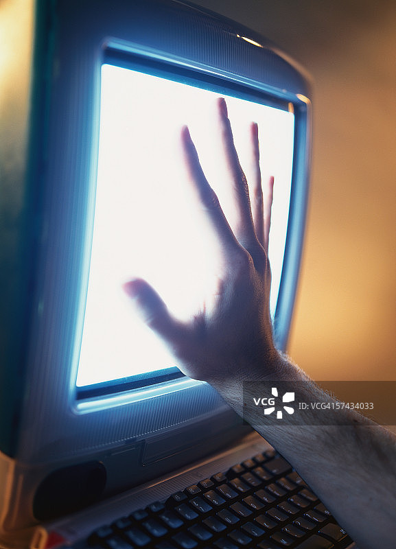 手与电脑屏幕的特写图片素材