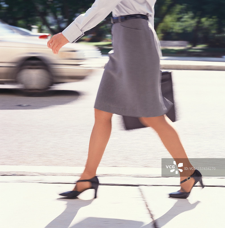 在人行道上行走的女人图片素材