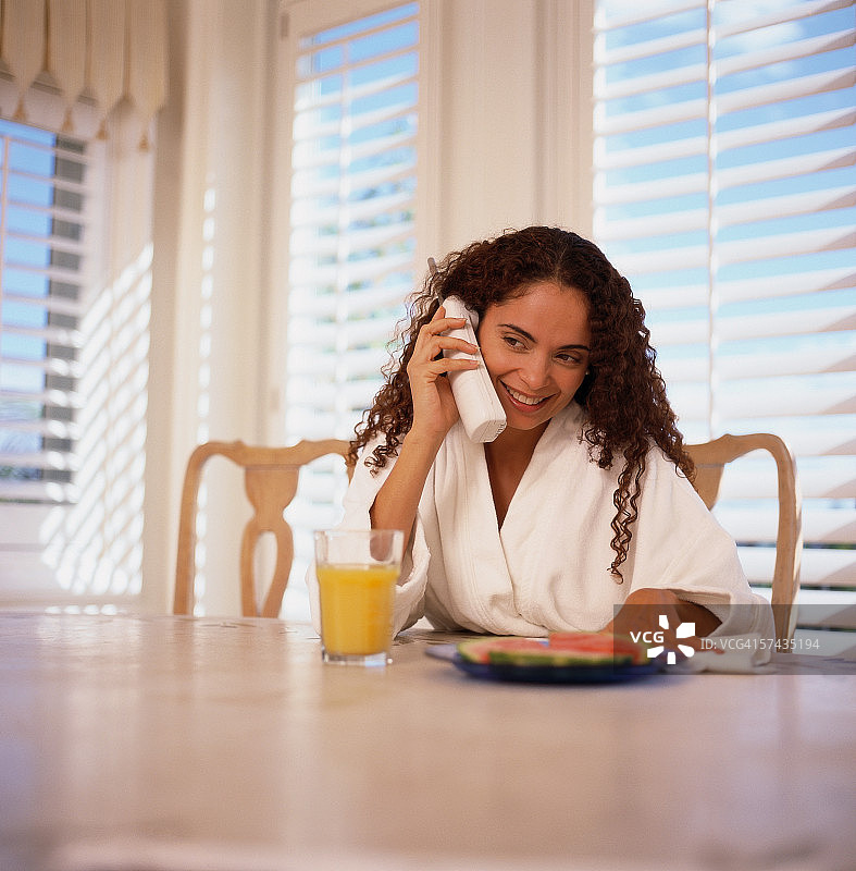 穿着浴袍用无线电话交谈的女人肖像图片素材