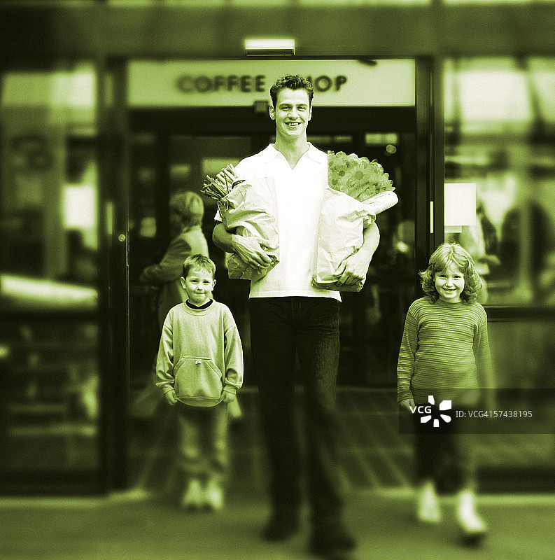 黑白肖像：年轻男子手提购物袋与孩子同行图片素材