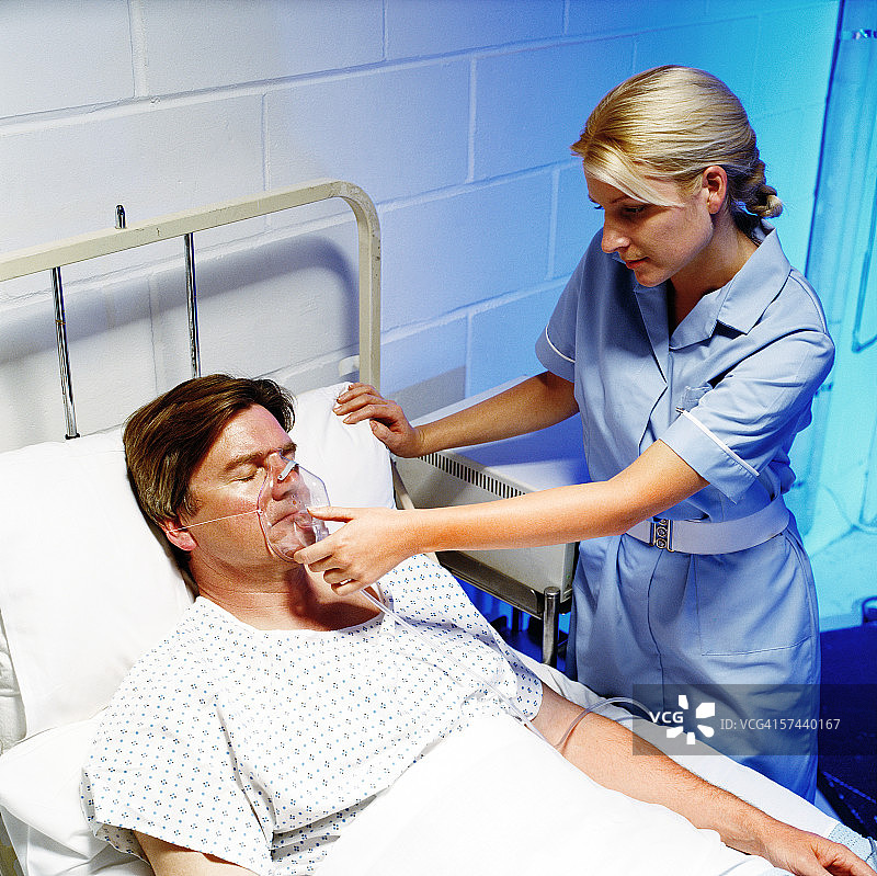 高角度拍摄：护士给病人戴氧气面罩图片素材