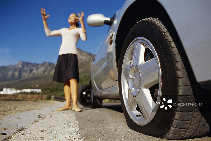 轮胎漏气的汽车和一个女人图片素材