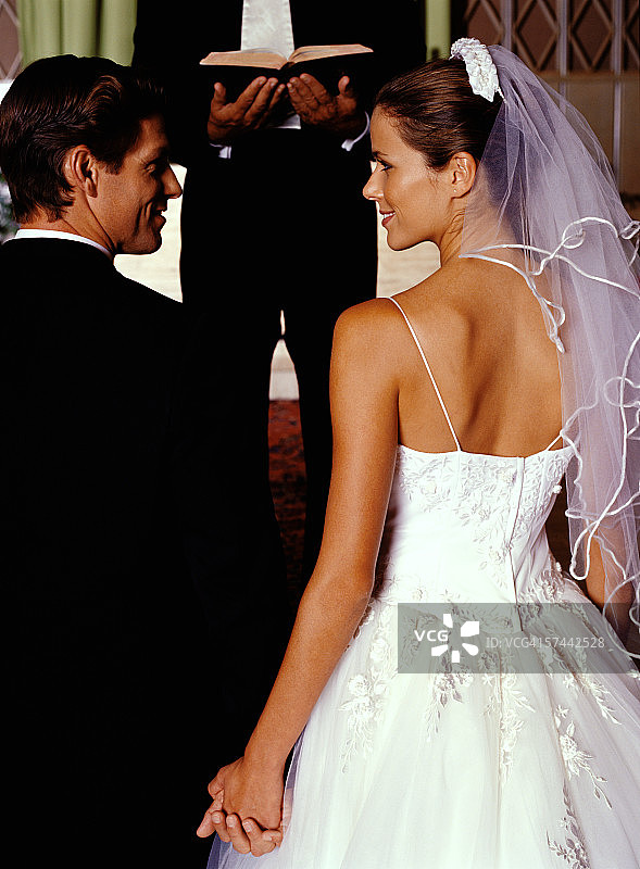 新娘和新郎在圣坛上手牵着手的肖像图片素材