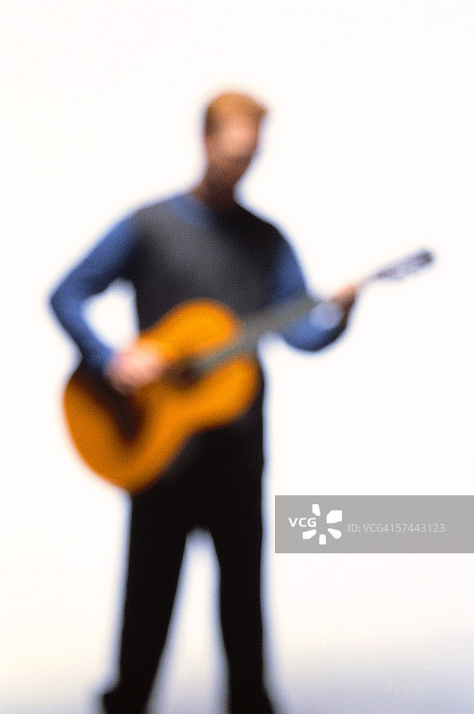 弹奏原声吉他的人的模糊照片图片素材