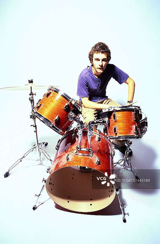 年轻人坐在鼓前肖像图片素材