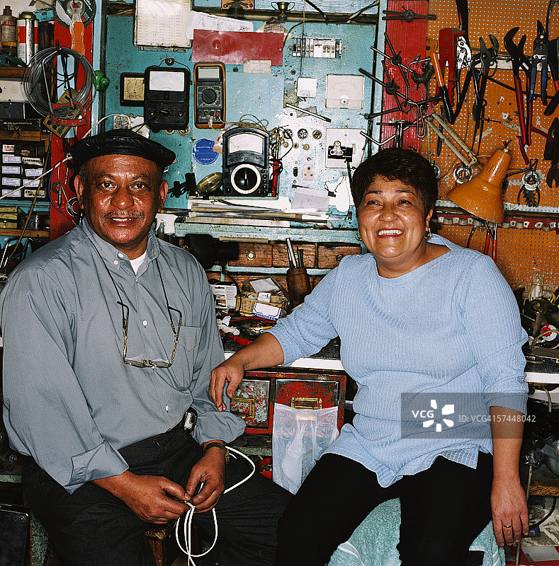 坐在电气车间的中年夫妇的肖像图片素材