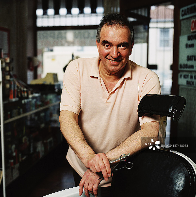 理发师倚靠在理发椅上的肖像图片素材