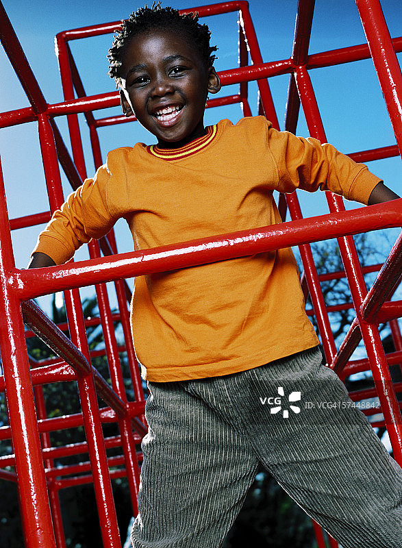 在公园的儿童乐园玩耍的年轻男孩（6-8岁）肖像图片素材