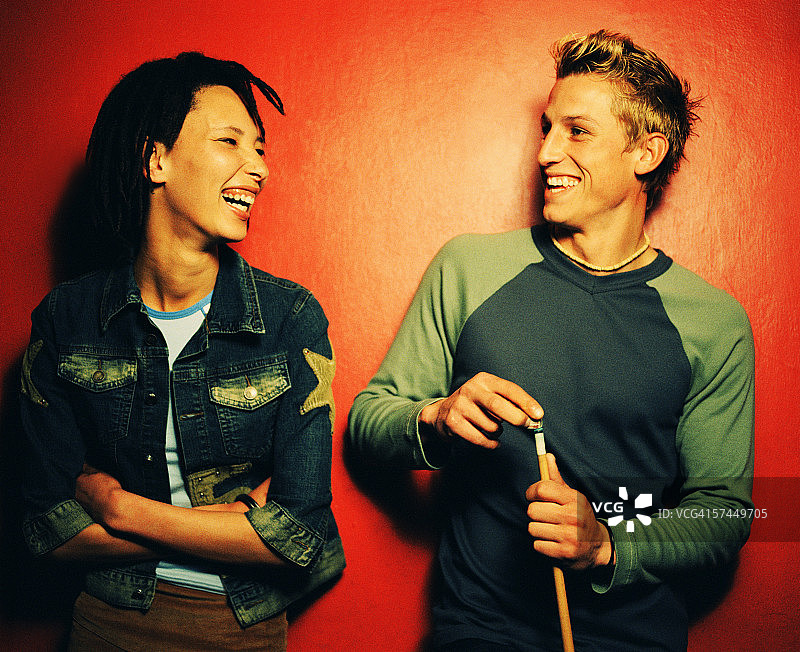 年轻女子与手持台球杆的男子交谈图片素材