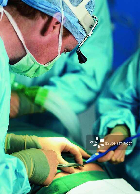 外科医生进行外科手术的侧面照图片素材