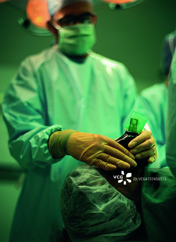 外科医生手持氧气面罩在病人脸上的特写图片素材