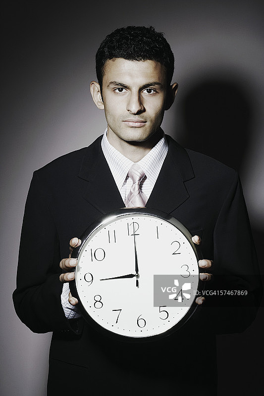 手拿时钟的商人肖像图片素材