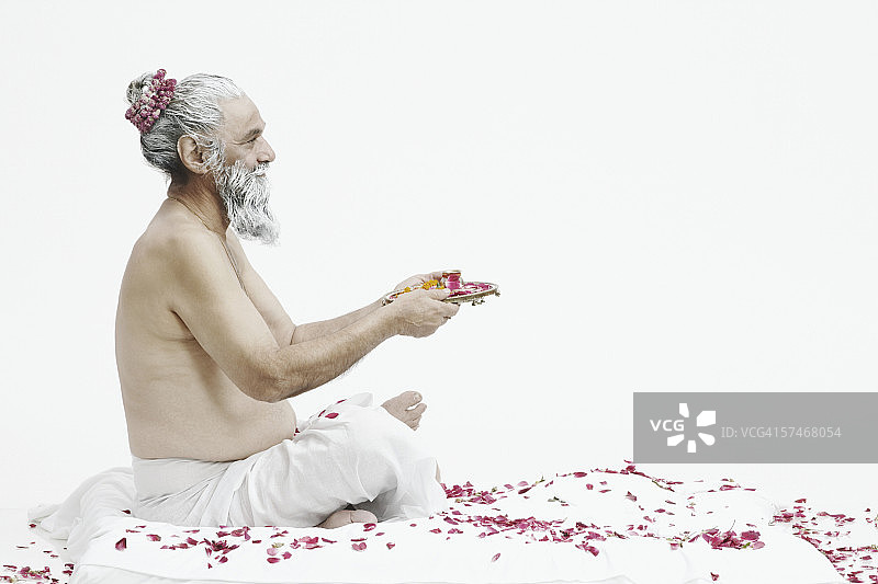 手持宗教祭品的牧师侧面照图片素材