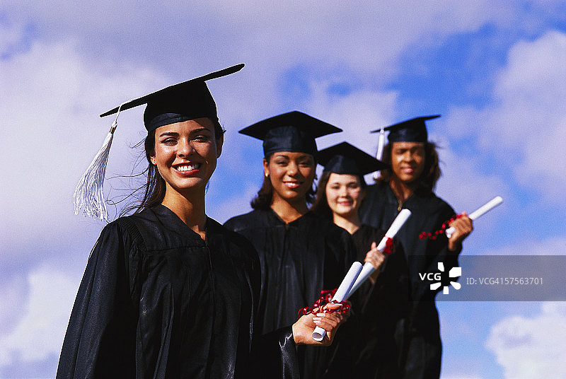 四个年轻女孩毕业时拿着学位的肖像图片素材