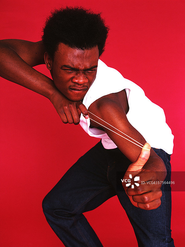 年轻男人用手指拉伸橡皮筋图片素材