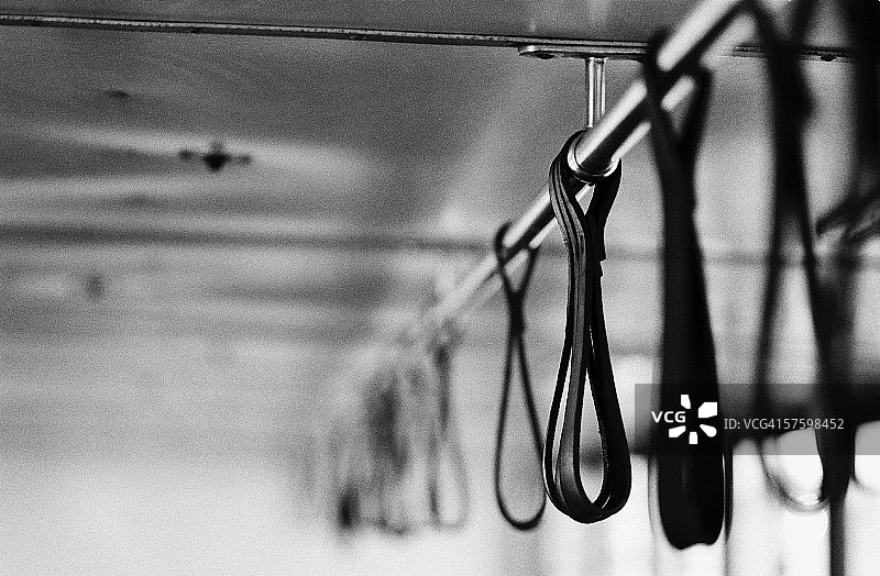 公共汽车顶棚杆上悬挂的皮带（黑白）图片素材