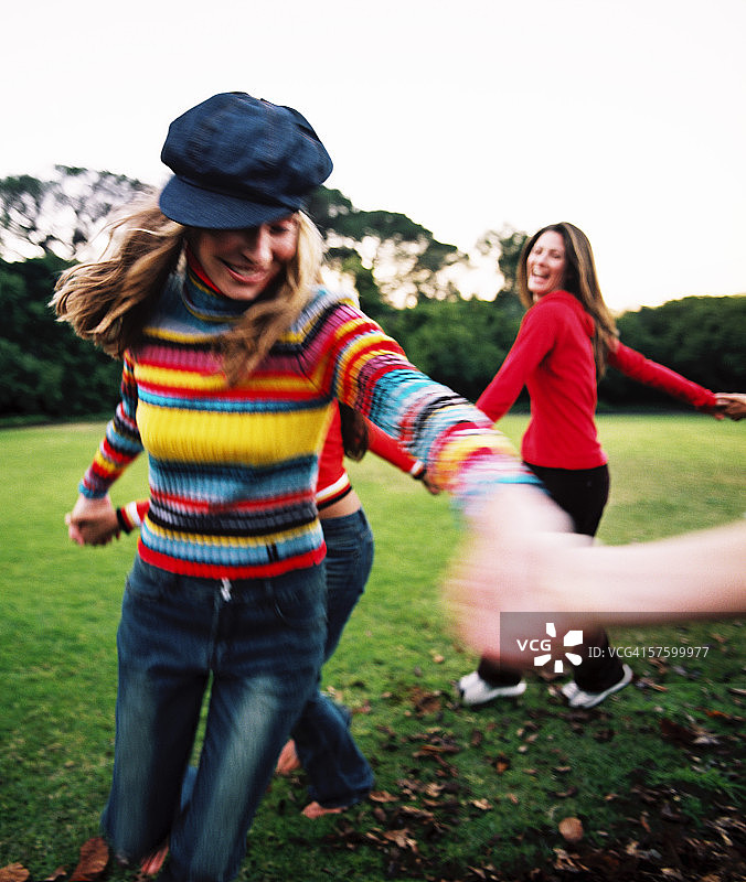 年轻女性手牵手玩耍图片素材