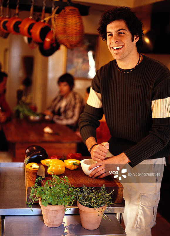 年轻男子在厨房里用研钵和研杵图片素材