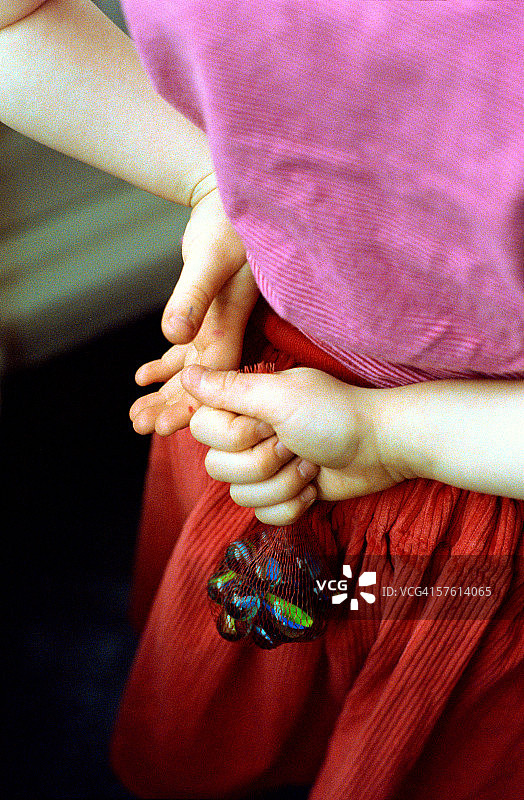 年轻女人双手背后拿着弹珠袋图片素材