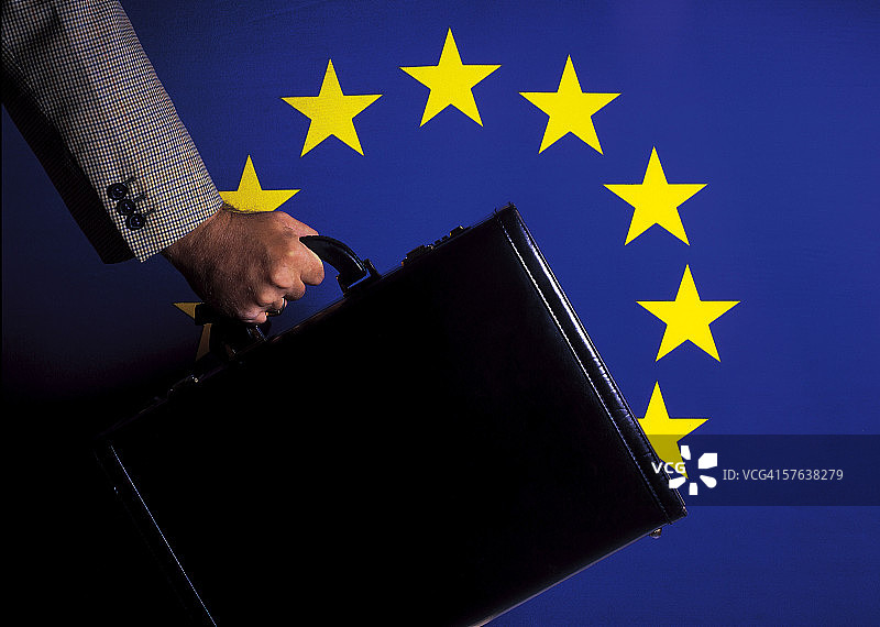 男人手提公文包，背景为欧盟旗帜图片素材
