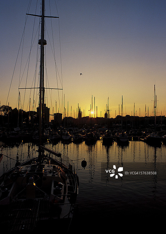 日落时分停靠在港口的船只剪影图片素材