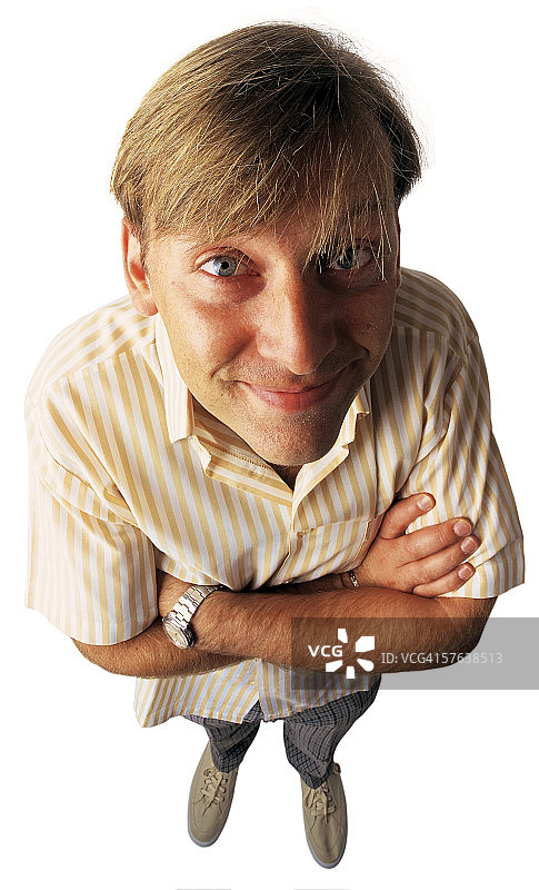 高角度拍摄：手臂交叉、微笑的年轻男人图片素材