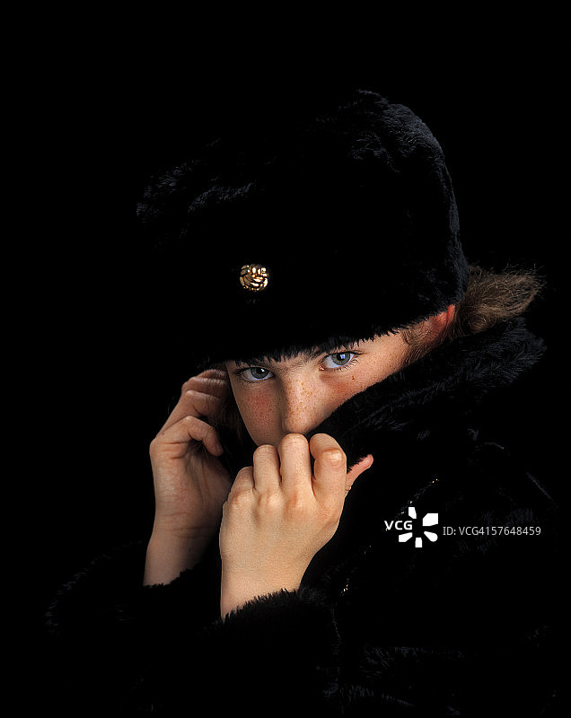 用皮草大衣领子遮住脸的小女孩图片素材