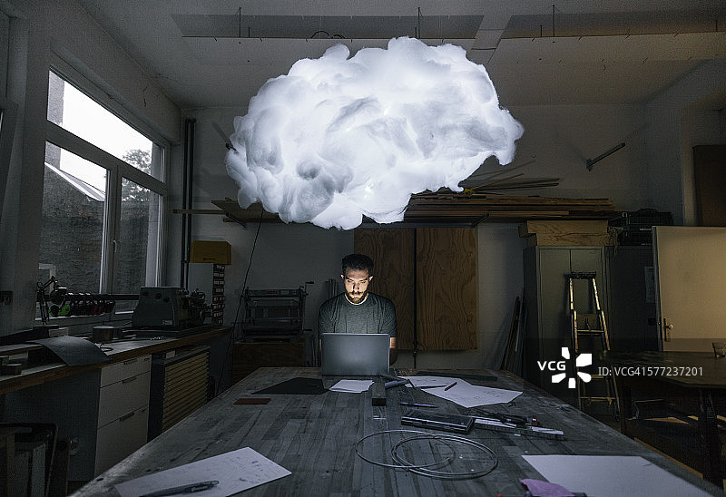 男人坐在工作台旁制作原型图片素材