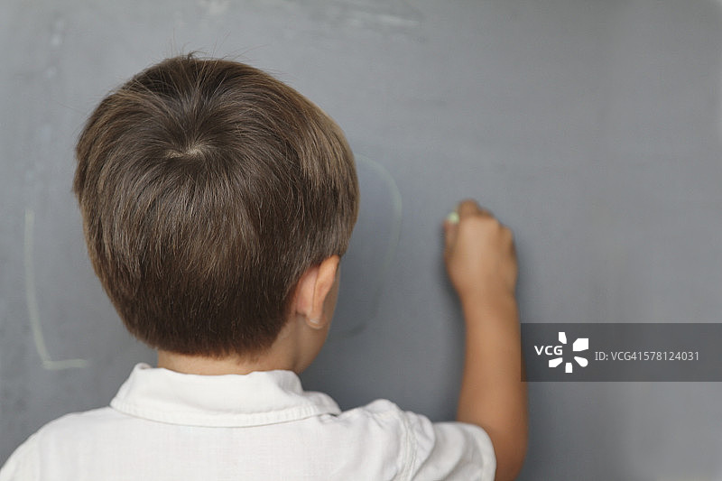 课堂上在黑板上写作的小学生图片素材