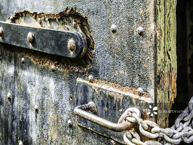 门上的锈蚀螺栓、锁闩、链条和把手图片素材