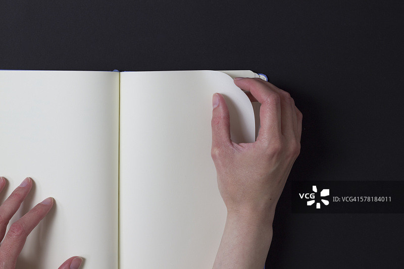 女人翻开空白笔记本的一页图片素材